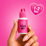 Hand holding a small pink bottle labeled 'Your BFF' against a pink background