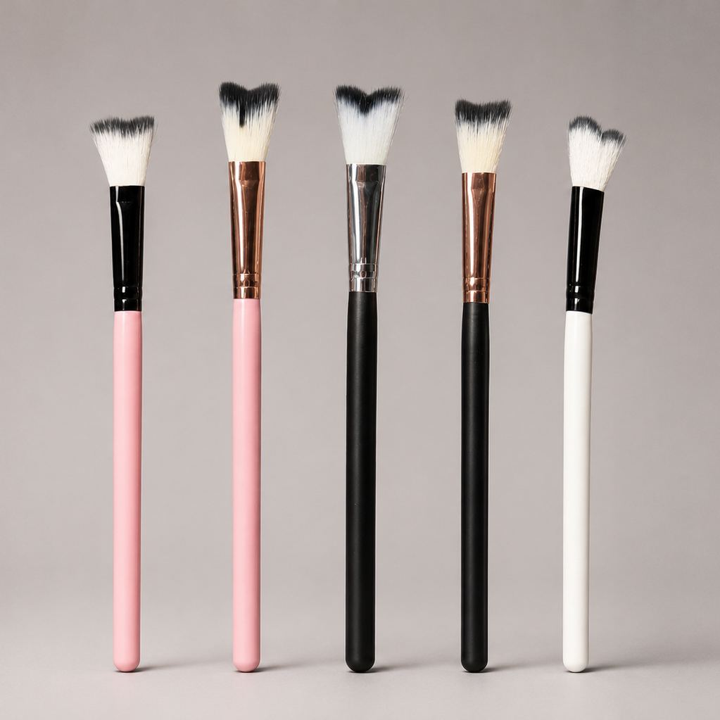 Set of makeup brushes with black, pink, and white handles on a gray background