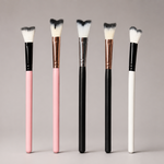 Set of makeup brushes with black, pink, and white handles on a gray background
