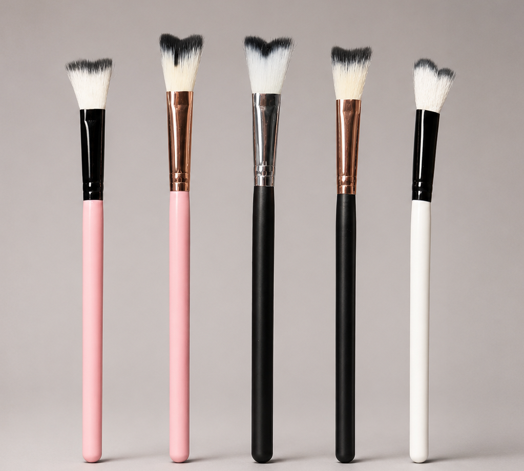 Set of makeup brushes with black, pink, and white handles on a gray background