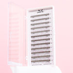 Set of false eyelashes in a holder on a pink background