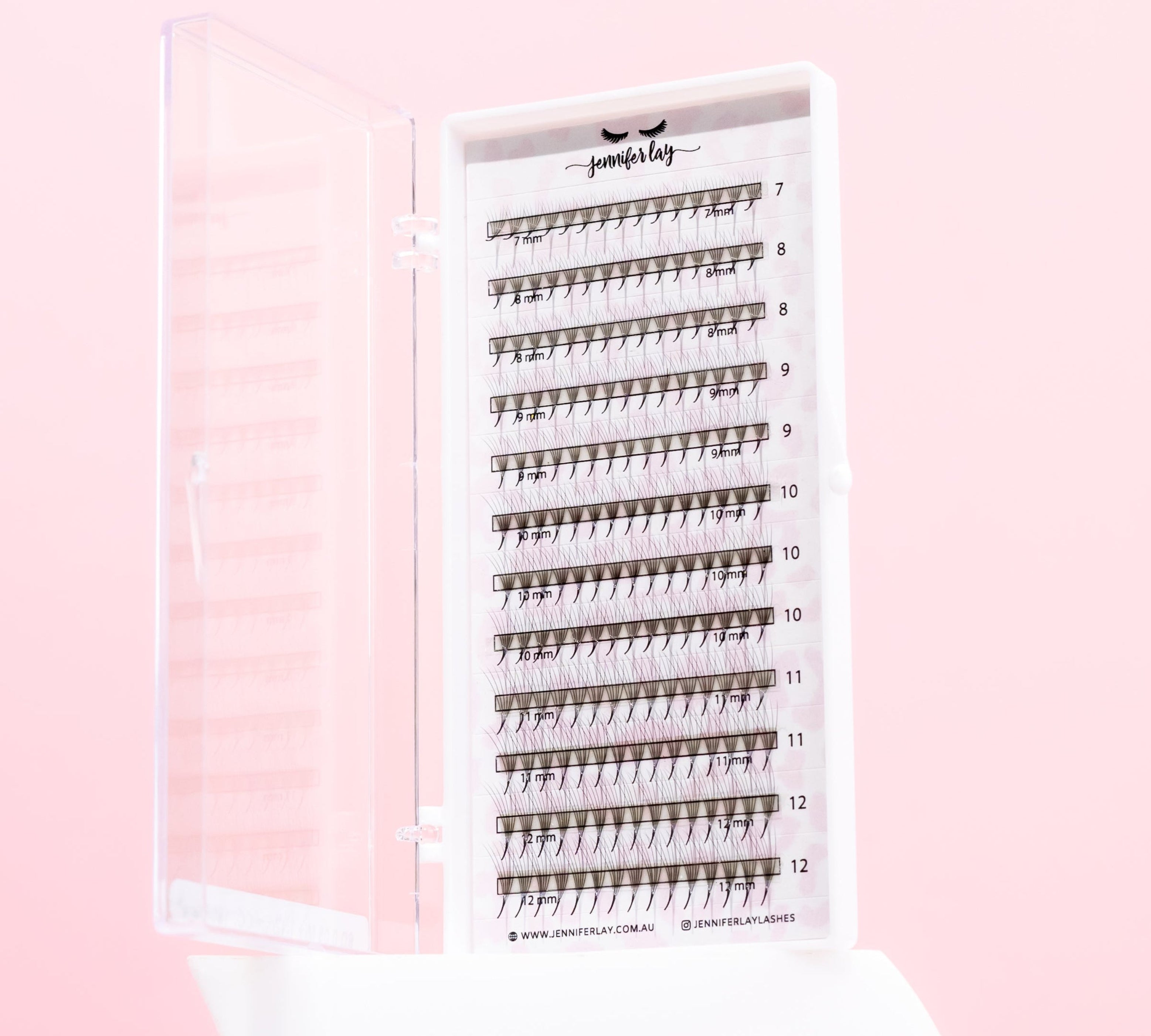 Set of false eyelashes in a holder on a pink background