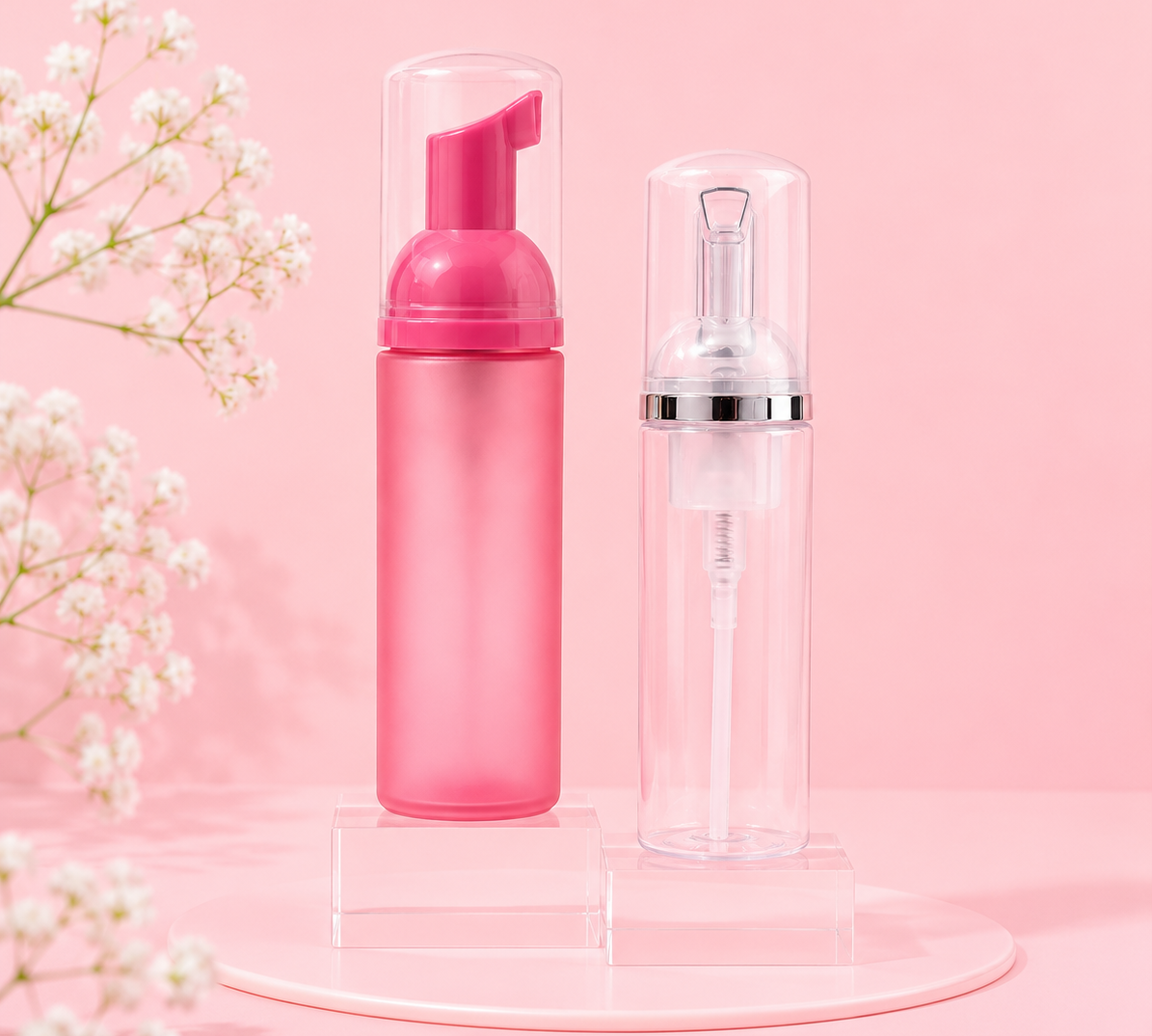 Pink foaming bottle and clear spray bottle on a pink background with white flowers.