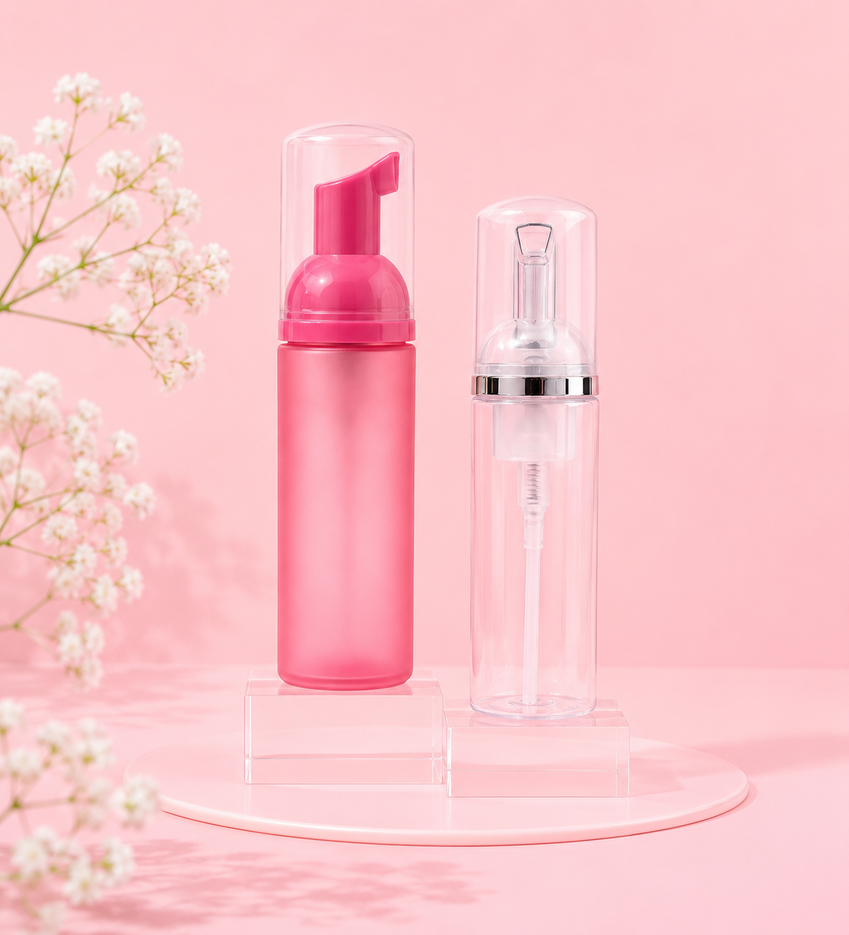 Pink foaming bottle and clear spray bottle on a pink background with white flowers.