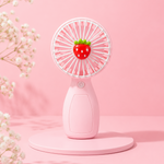 Pink handheld fan with strawberry design on a pink background